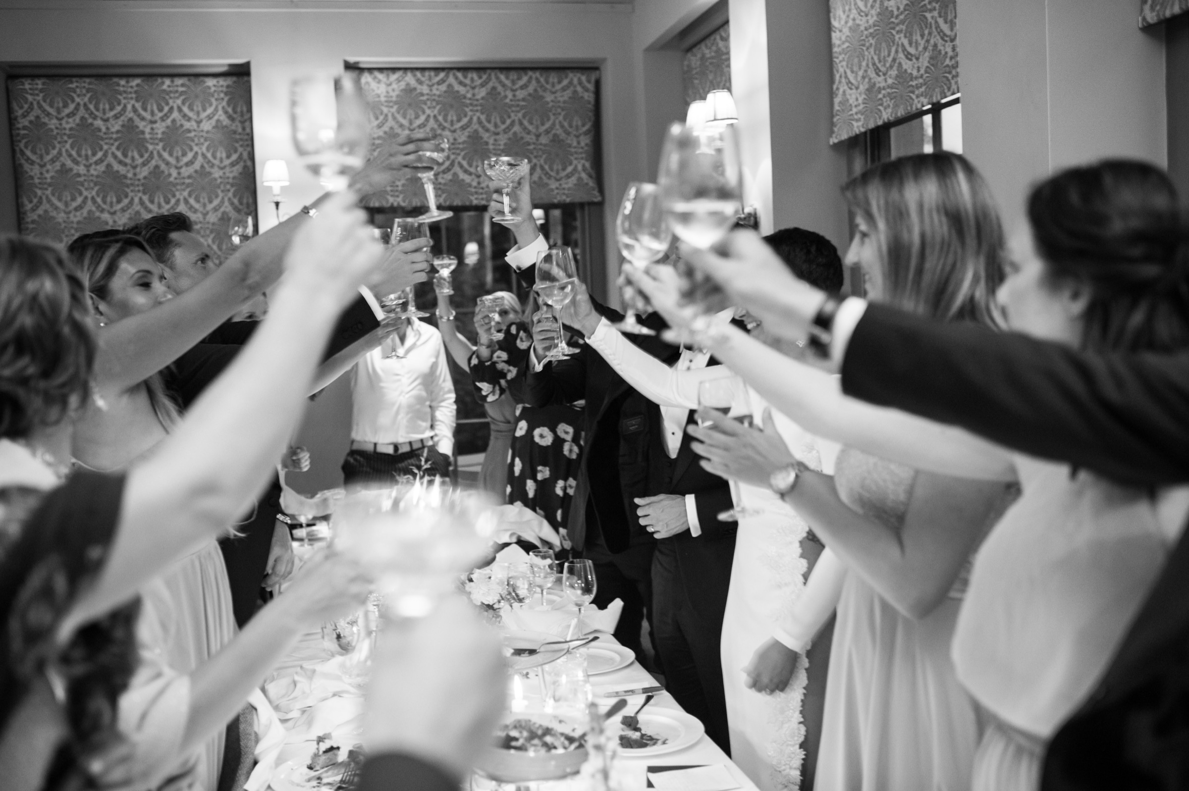 wedding guests toasting in celebration with champagne glasses